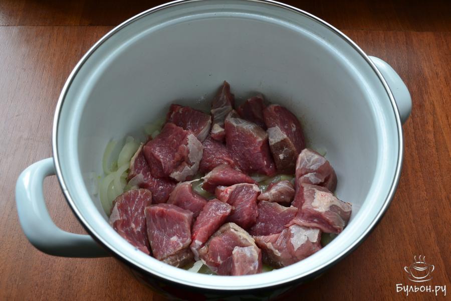 К луку добавить говядину, обжаривать вместе с луком до легкой румяности мяса.