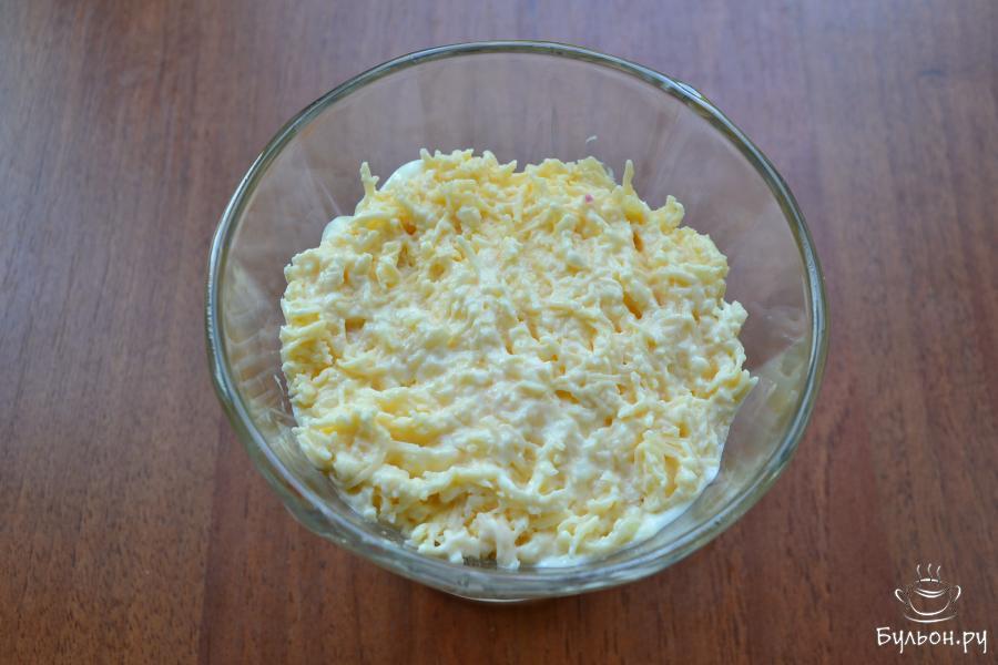 Следующий слой салата - сыр с чесноком.