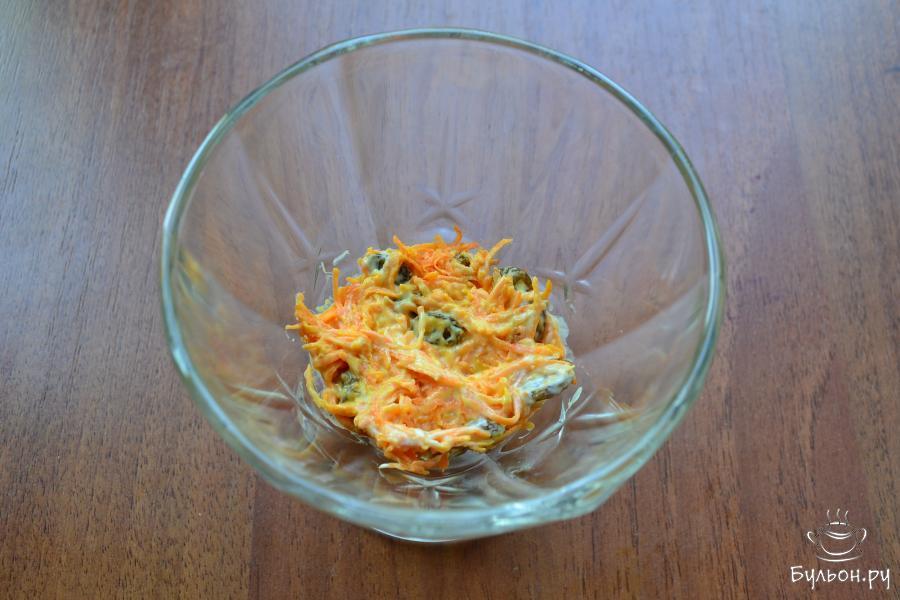 В небольшой салатник или креманку салат нужно выкладывать слоями: первый слой - половина смеси моркови и изюма.