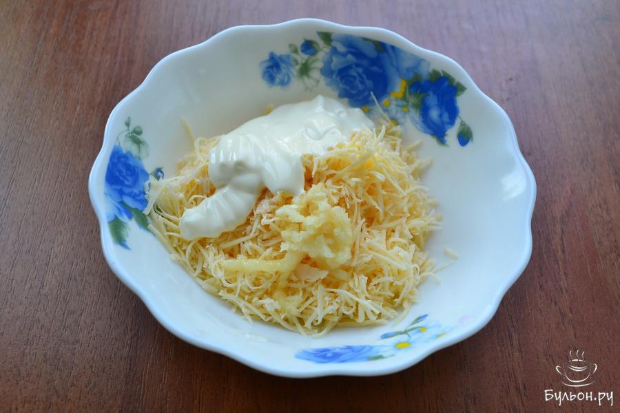 Твердый или полутвердый сыр нужно натереть на терке с мелкими отверстиями. Добавить к сыру очищенный и измельченный чеснок, сюда же, добавить и майонез.