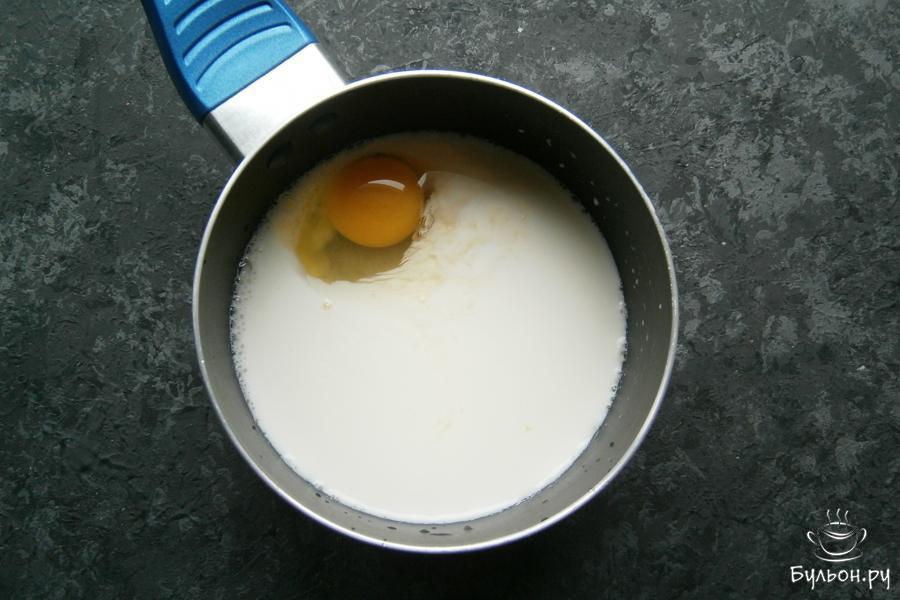 В другую посуду влить оставшиеся 200 мл холодного молока, добавить небольшое сырое яйцо, всыпать сахар.