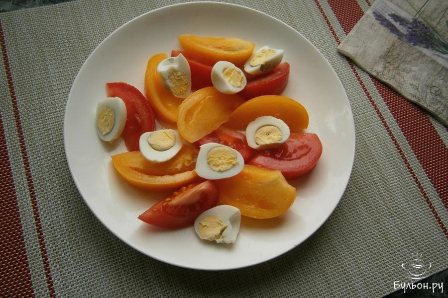 Помидоры порезать дольками и разложить их на плоской тарелке. Яйца очистить, разрезать на половинки и выложить между помидорами.