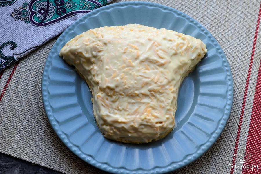 Кусочек сыра (граммов 20) отрезать и оставить для украшения. Весь салат покрыть оставшимся (и сверху, и по бокам) натертым твердым сыром, который аккуратно промазать майонезом.
