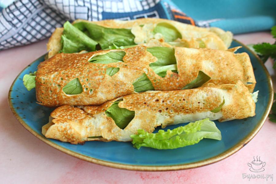 Рваные блины с листьями салата и красной рыбой